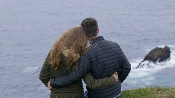 Happy scene of two friends in love looking over the ocean — Stock Photo, Image