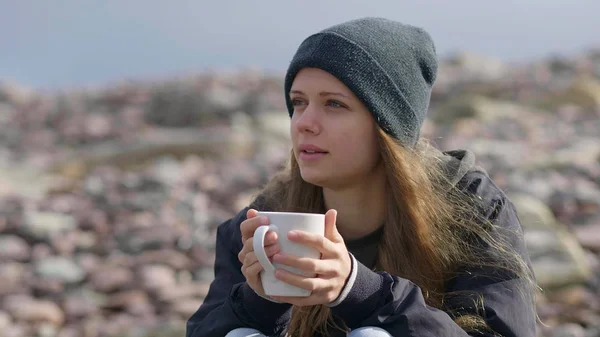 Bella ragazza con una tazza di caffè seduta sul lungomare — Foto Stock