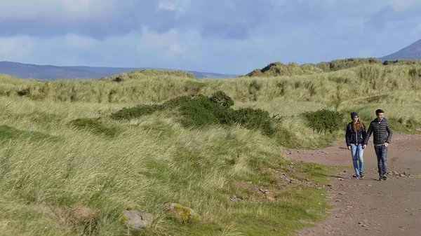 Relajante paseo por las dunas cubiertas de hierba de Irlanda — Foto de Stock