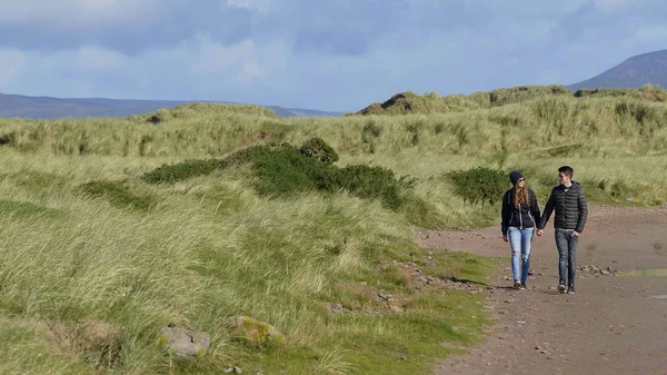 Relajante paseo por las dunas cubiertas de hierba de Irlanda — Foto de Stock