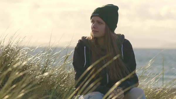 Meisje zit in reed gras en houdt van het land van Ierland — Stockfoto