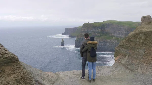 Girl hugs her boyfriend at the Cliffs of Moher in Ireland — Stock Photo, Image