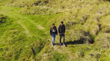 İrlanda şaşırtıcı doğa ile yürüyen bir genç çift üzerinde havadan görünümü