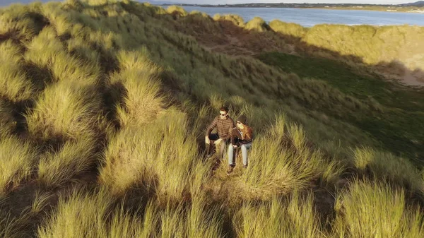 Aerial view over a couple sitting on the dunes at the Irish west coast — Stock Photo, Image