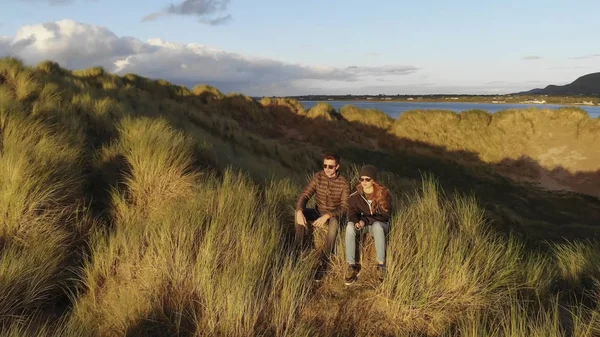 Pareja joven enamorada disfruta de la puesta de sol sobre el océano — Foto de Stock