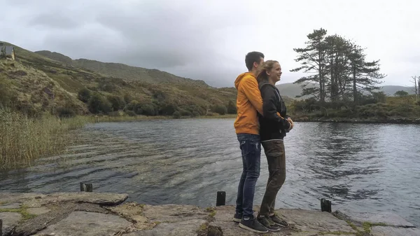 Młody mężczyzna przytula swoją dziewczyną romantyczne jezioro — Zdjęcie stockowe