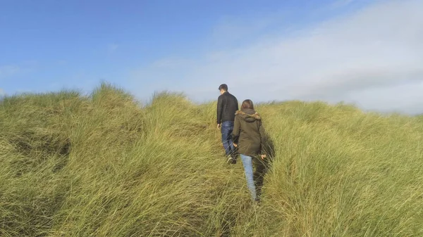 Two people walk through the typical nature of the Irish grasslands — Stock Photo, Image