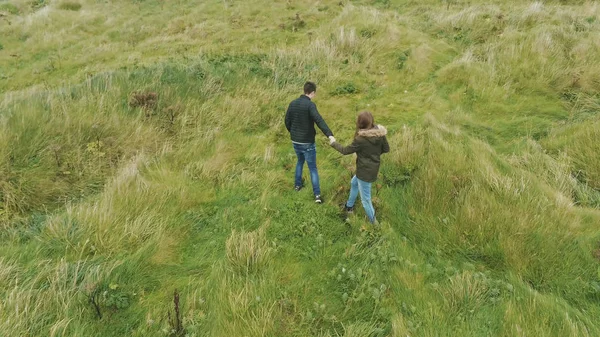 情侣漫步在爱尔兰丁格尔半岛的草地上 — 图库照片