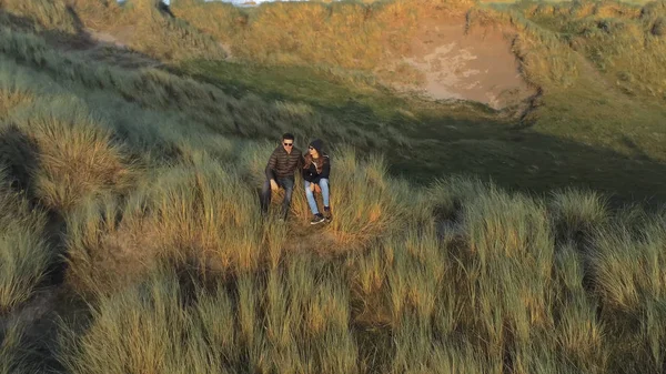 Aerial view over a couple sitting on the top of the dunes at the Irish west coast — Stock Photo, Image