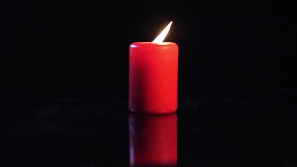Маленькое пламя на черном фоне свечи — стоковое видео