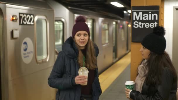 Duas mulheres em uma plataforma de uma estação de metrô de Nova York esperam por seu trem — Vídeo de Stock