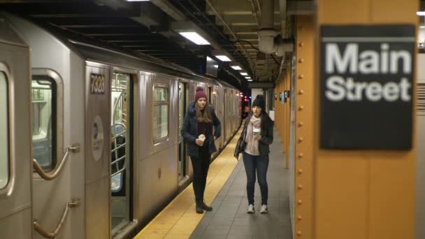 Duas mulheres em uma plataforma de uma estação de metrô de Nova York esperam por seu trem — Vídeo de Stock