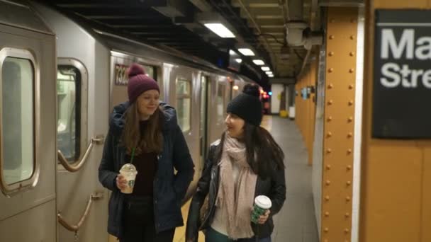 Duas mulheres em uma plataforma de uma estação de metrô de Nova York esperam por seu trem — Vídeo de Stock