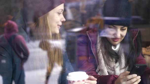 Twee vrienden drinken koffie in een café met het oog op de straat — Stockvideo