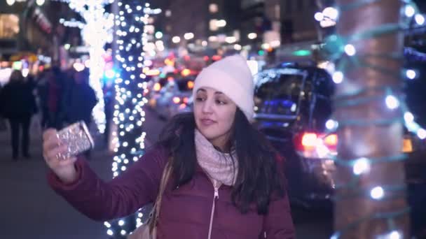 Молодая женщина делает селфи во время покупок на Рождество — стоковое видео