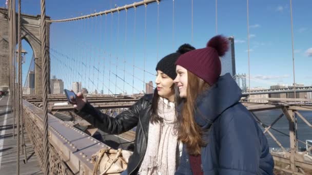 Dos chicas caminan por el famoso puente de Brooklyn en Nueva York — Vídeo de stock