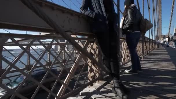 Две девушки идут по знаменитому Бруклинскому мосту в Нью-Йорке — стоковое видео