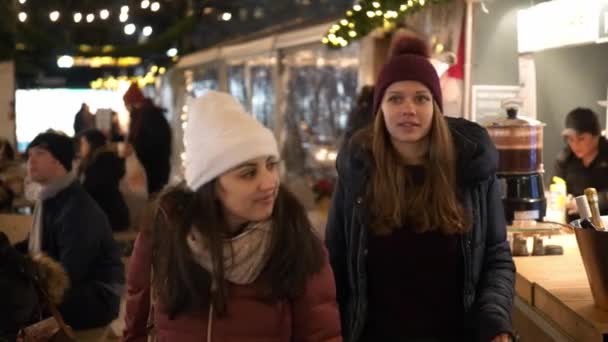 Jeune femme cherche des cadeaux sur un marché de Noël — Video