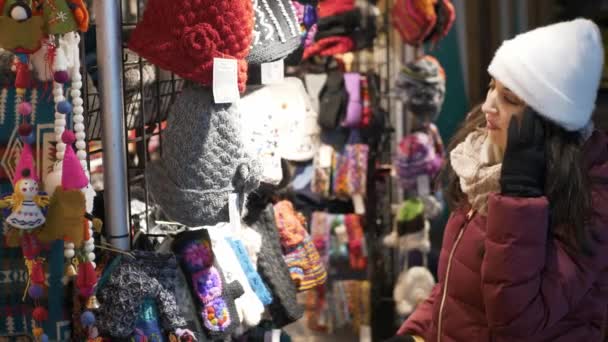 Jeune femme cherche des cadeaux sur un marché de Noël — Video