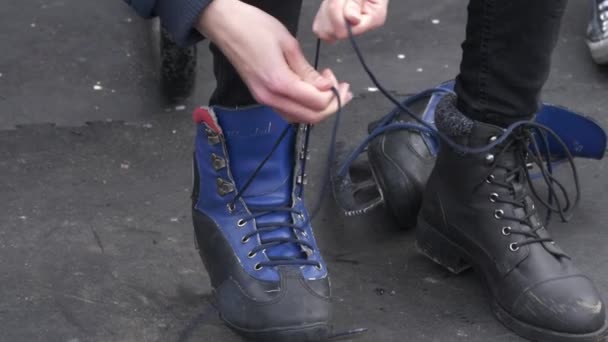 Young skater puts on the ice skating shoes — Stock Video