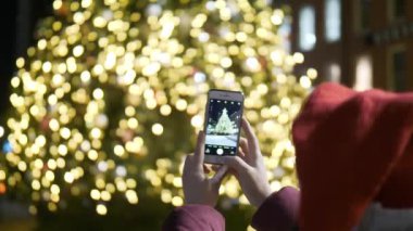 Genç kadın New York'ta büyük bir Noel ağacının bir fotoğrafı çeker