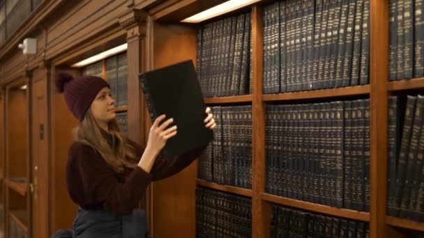 Joven estudiante en una biblioteca — Vídeos de Stock