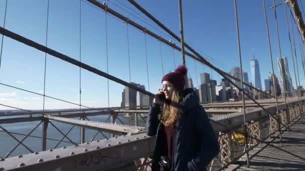 Joven hermosa mujer se relaja en el puente de Brooklyn mientras disfruta de la increíble vista — Vídeo de stock