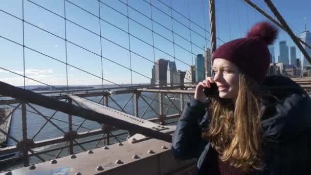 Ung vacker kvinna slappnar på Brooklyn Bridge medan du njuter av den fantastiska utsikten — Stockvideo