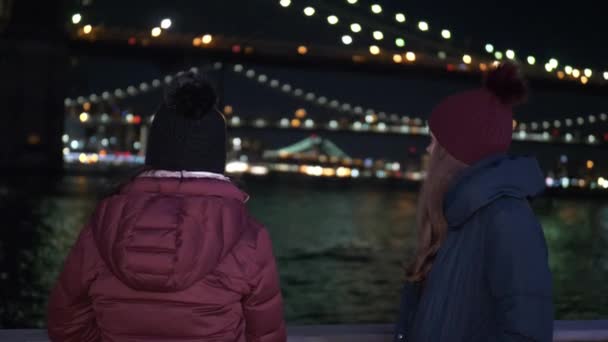 Två tjejer i New York njuta av den vackraste platsen i staden vid Brooklyn Bridge — Stockvideo