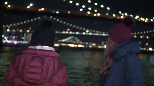 Dos chicas en Nueva York disfrutan del lugar más hermoso de la ciudad en Brooklyn Bridge — Vídeo de stock