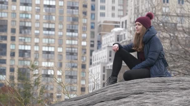 Genç kadın bir kayaya, New York Central Park rahatlatır — Stok video