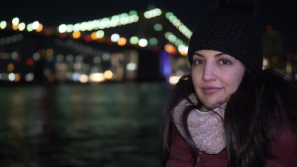 Retrato de una joven en el puente de Brooklyn por la noche — Vídeo de stock