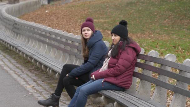 Дві дівчини в центральному парку Нью-Йорк присісти на лавку для відпочинку — стокове відео