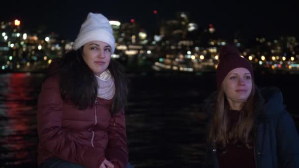 Две девушки ночью исследуют Нью-Йорк здесь, на Бруклинском мосту. — стоковое видео