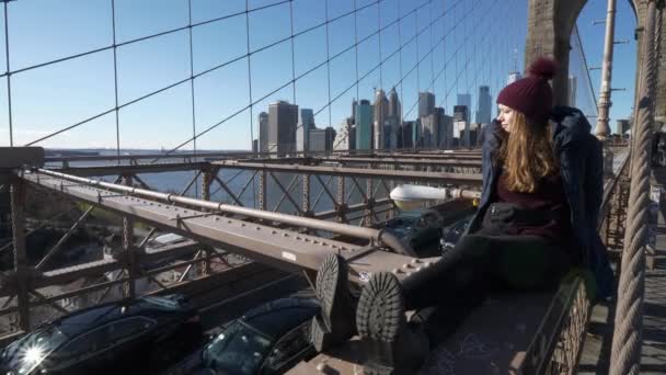 Menina jovem e imprudente senta-se na borda da Brooklyn Bridge New York — Vídeo de Stock