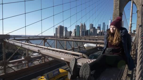 Joven hermosa mujer en Brooklyn Bridge Nueva York disfruta de un maravilloso día soleado — Vídeo de stock