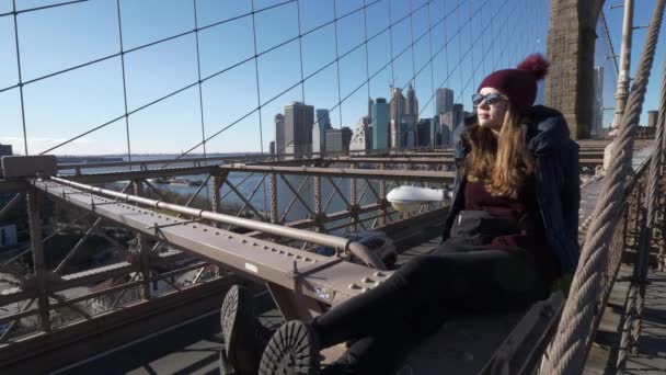 年轻美丽的女人在布鲁克林大桥纽约享受一个美妙的阳光明媚的一天 — 图库视频影像