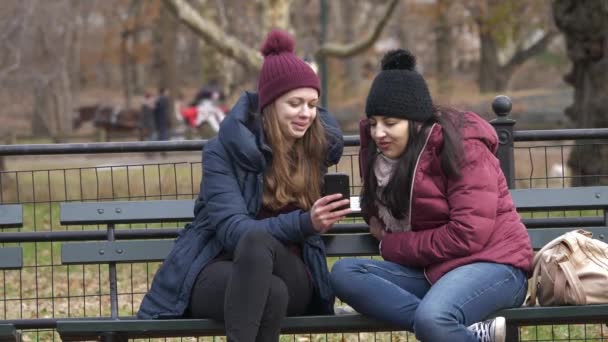 Dva přátelé Podívejte se na fotky na svém mobilním telefonu — Stock video