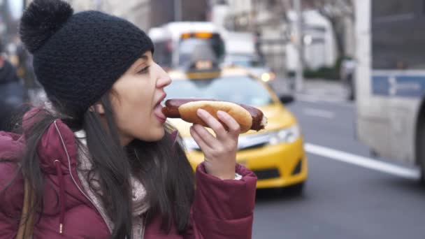 Fiatal nő eszik egy forró kutya az utcán a New York-i — Stock videók