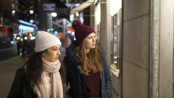 Två tjejer på en shoppingtur i New York gå längs skyltfönstren — Stockvideo