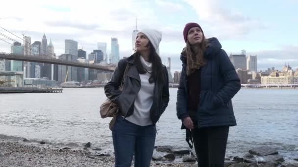 New York'ta iki genç kadın nefes kesen Manhattan siluetinin tadını çıkarın. — Stok video