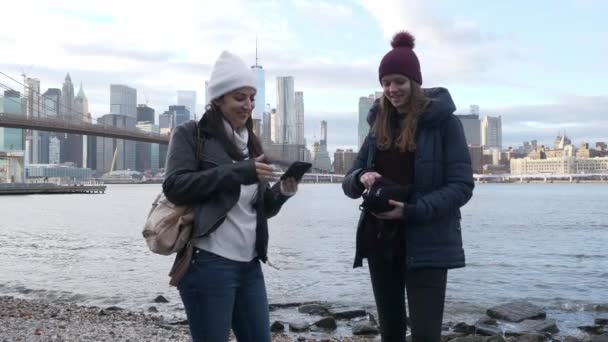 New York'ta iki genç kadın nefes kesen Manhattan siluetinin tadını çıkarın. — Stok video