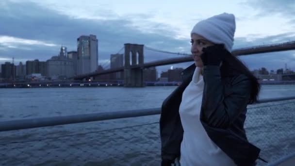 Mladá žena chodí podél nádherné panorama Manhattanu večer — Stock video