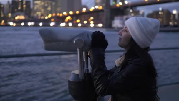 Mujer joven mira a través de un catalejo en Brooklyn Bridge Nueva York — Vídeos de Stock