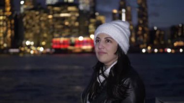 Genç kadın geceleri üzerinde Manhattan siluetinin muhteşem manzarası sahiptir