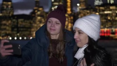 İki kız harika bir gece New York'ta Manhattan siluetinin önünde zevk
