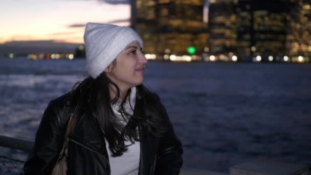 Jonge vrouw geniet het fantastische uitzicht over de skyline van Manhattan bij nacht — Stockvideo