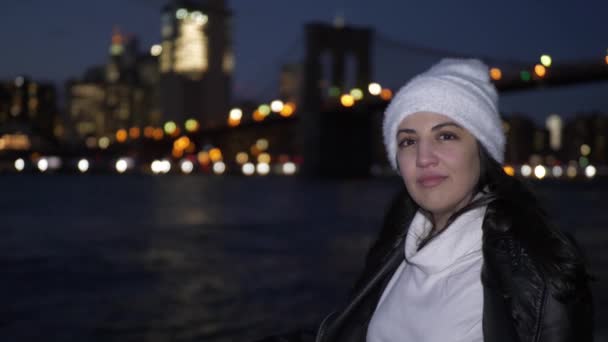 若い女性夜マンハッタンのスカイラインの素晴らしい景色を楽しんでいます。 — ストック動画