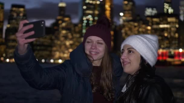 Duas garotas desfrutam de uma noite maravilhosa em Nova York em frente ao horizonte de Manhattan — Vídeo de Stock