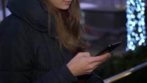 Νεαρή γυναίκα στέλνει ένα μήνυμα κειμένου στο κινητό της — Αρχείο Βίντεο